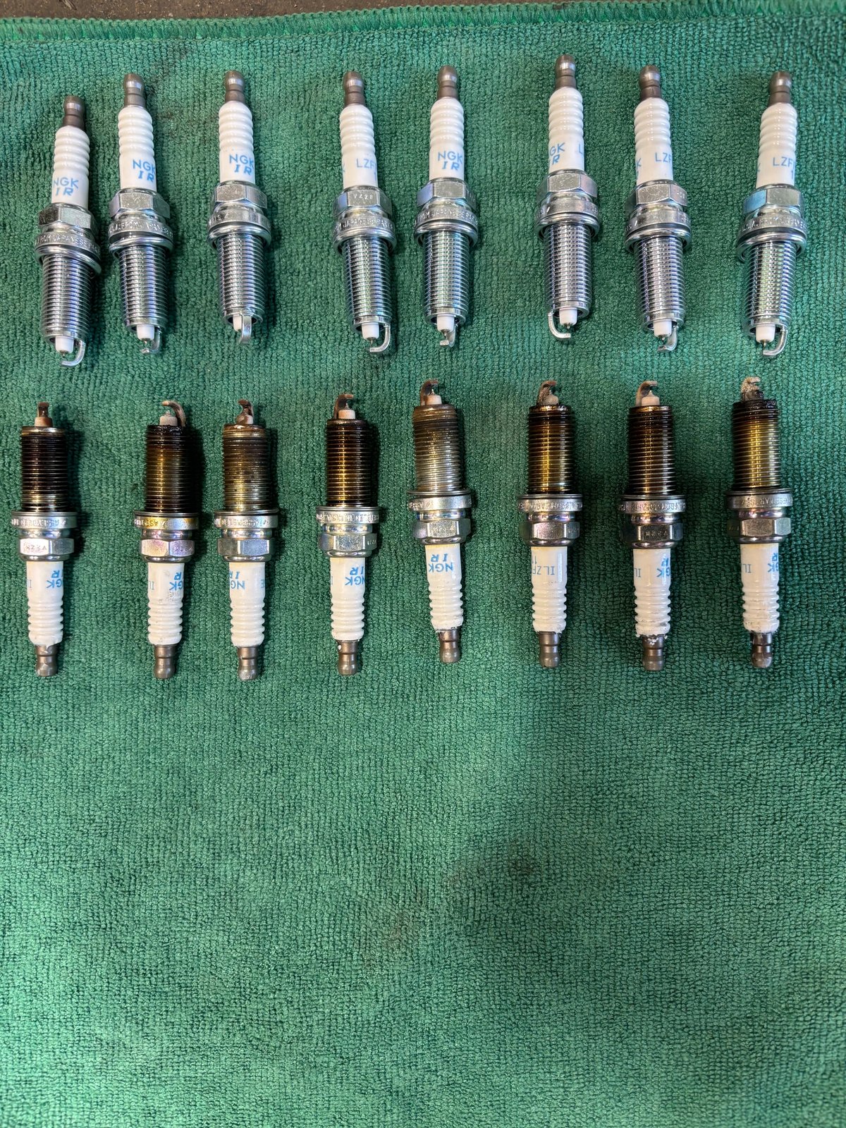 New and worn spark plugs compared during an engine tune-up